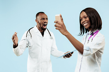 Image showing The female and male happy afro american doctors on blue background