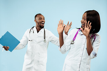 Image showing The female and male happy afro american doctors on blue background