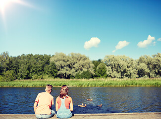 Image showing couple on river berth looking at swimming ducks