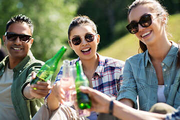 Image showing happy friends clinking drinks outdoors in summer