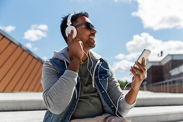 Image showing man with smartphone and headphones on roof top