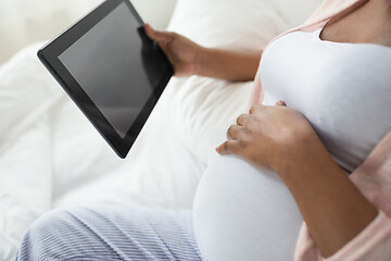 Image showing close up of pregnant woman with tablet pc at home