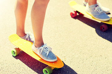 Image showing close up of female feet riding short skateboard