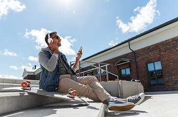 Image showing man with smartphone and headphones on roof top