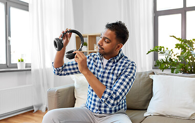 Image showing male blogger with headphones videoblogging at home