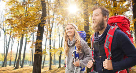 Image showing smiling couple with backpacks hiking in autumn