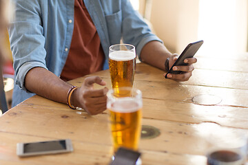 Image showing man with smartphone drinking beer at bar or pub