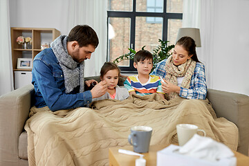 Image showing family with medicine treating ill children at home