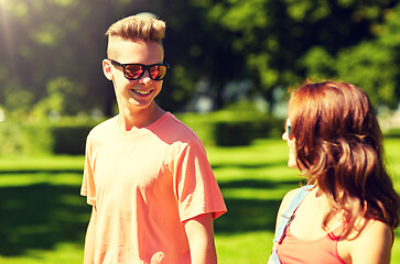 Image showing happy teenage couple walking at summer park