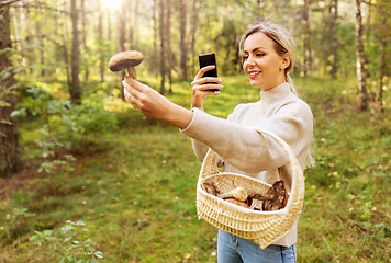 Image showing woman using smartphone to identify mushroom