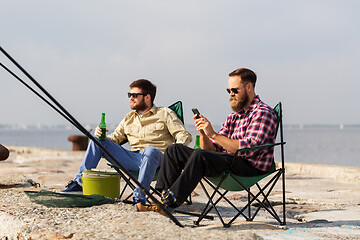 Image showing friends with smartphone fishing and drinking beer