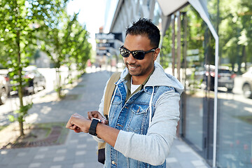 Image showing indian man with smart watch and backpack in city