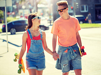 Image showing teenage couple with skateboards on city street