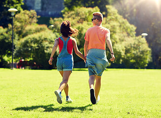 Image showing happy teenage couple walking at summer park