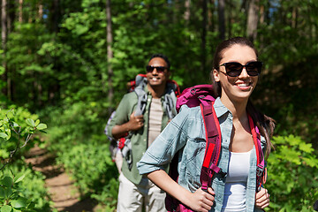 Image showing mixed race couple with backpacks hiking in forest