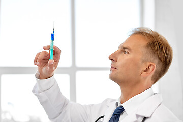 Image showing smiling doctor with syringe at hospital