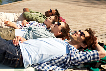 Image showing happy friends chilling on lake pier