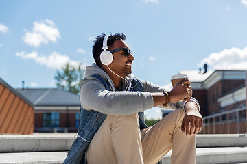 Image showing man in headphones listening to music on roof top