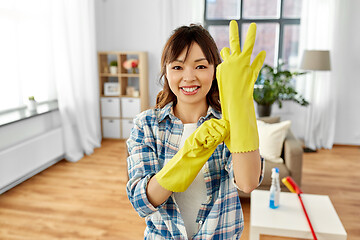 Image showing asian woman putting protective rubber gloves on