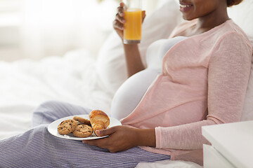 Image showing pregnant woman having breakfast in bed at home