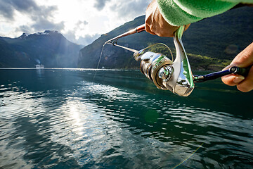 Image showing Woman fishing on Fishing rod spinning in Norway.