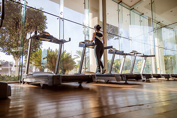 Image showing Woman running on treadmill in gym. Ealthy lifestyle.