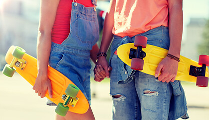 Image showing close up of young couple with skateboards in city