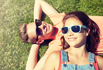 Image showing happy teenage couple lying on grass at summer