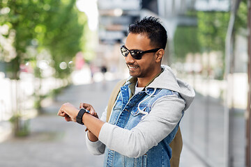 Image showing indian man with smart watch and backpack in city