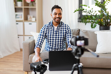 Image showing male blogger with camera videoblogging at home