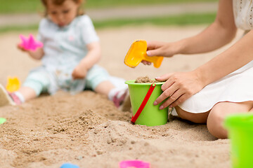 Image showing mother playing with baby daughter in sandbox