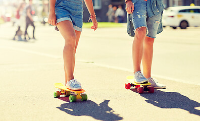 Image showing teenage couple riding skateboards on city street