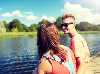 Image showing happy teenage couple sitting on river berth