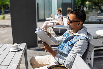 Image showing indian man reading book at street cafe