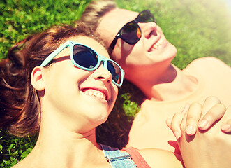 Image showing happy teenage couple lying on grass at summer