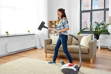 Image showing asian woman with vacuum cleaner having fun at home