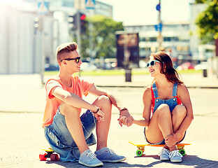 Image showing teenage couple with skateboards on city street