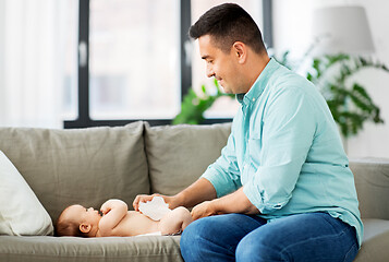 Image showing middle aged father changing baby\'s diaper at home