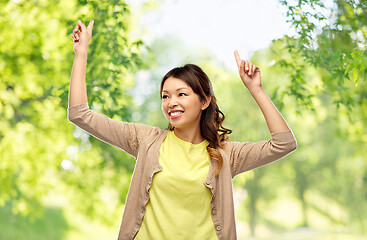 Image showing asian woman dancing over green natural background