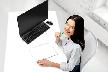 Image showing businesswoman writing to notebook at office