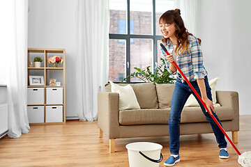 Image showing asian woman or housewife with mop singing at home