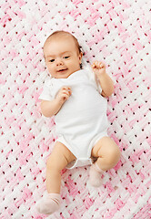 Image showing sweet baby girl lying on knitted plush blanket