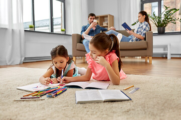 Image showing happy sisters drawing and doing homework at home