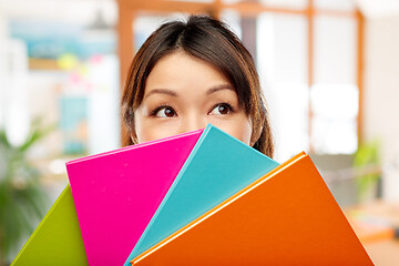 Image showing asian woman or student hiding behind notebooks