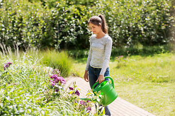 Image showing young woman watering flowers at garden