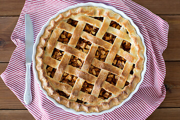 Image showing close up of apple pie in baking mold and knife