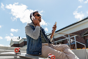 Image showing man with smartphone and headphones on roof top