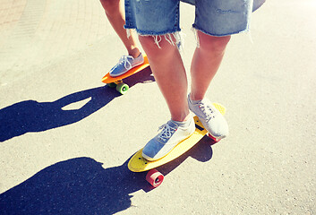 Image showing teenage couple riding skateboards on city road
