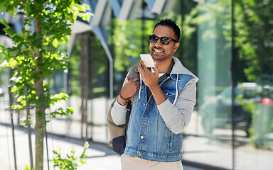 Image showing man recorving voice message on smartphone in city