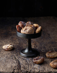 Image showing dried figs on rustic wooden table